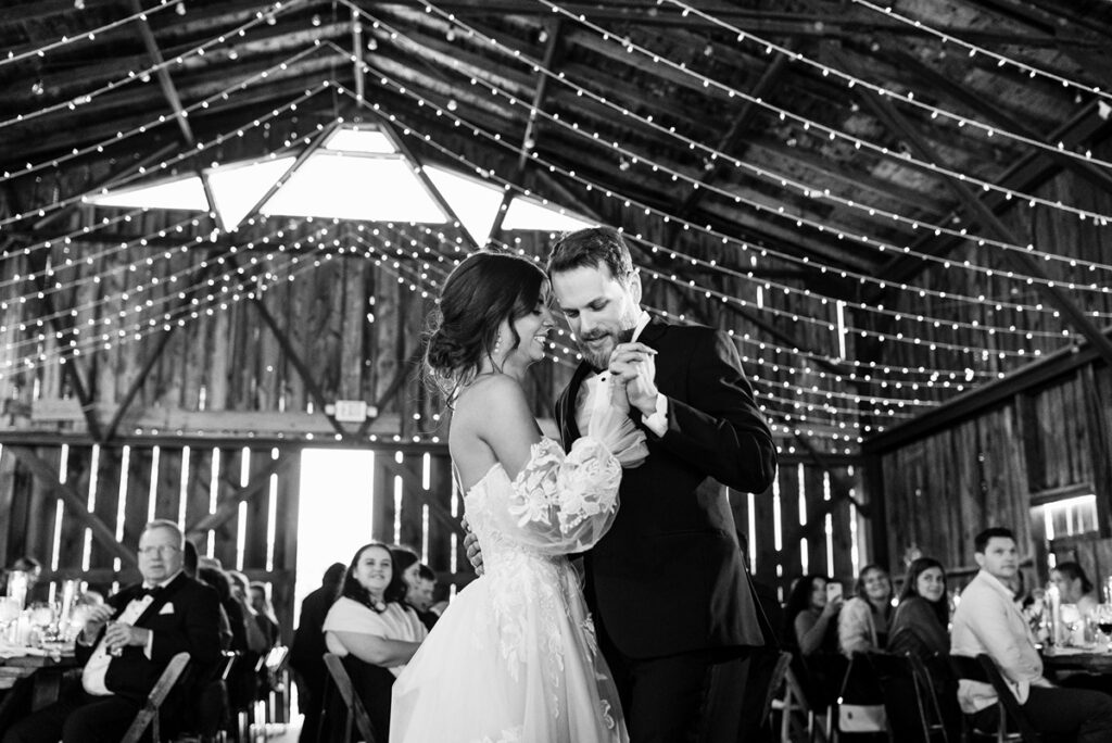 black and white photo of Bride and Groom dancing under string lights at Candlelight Farms Inn wedding venue