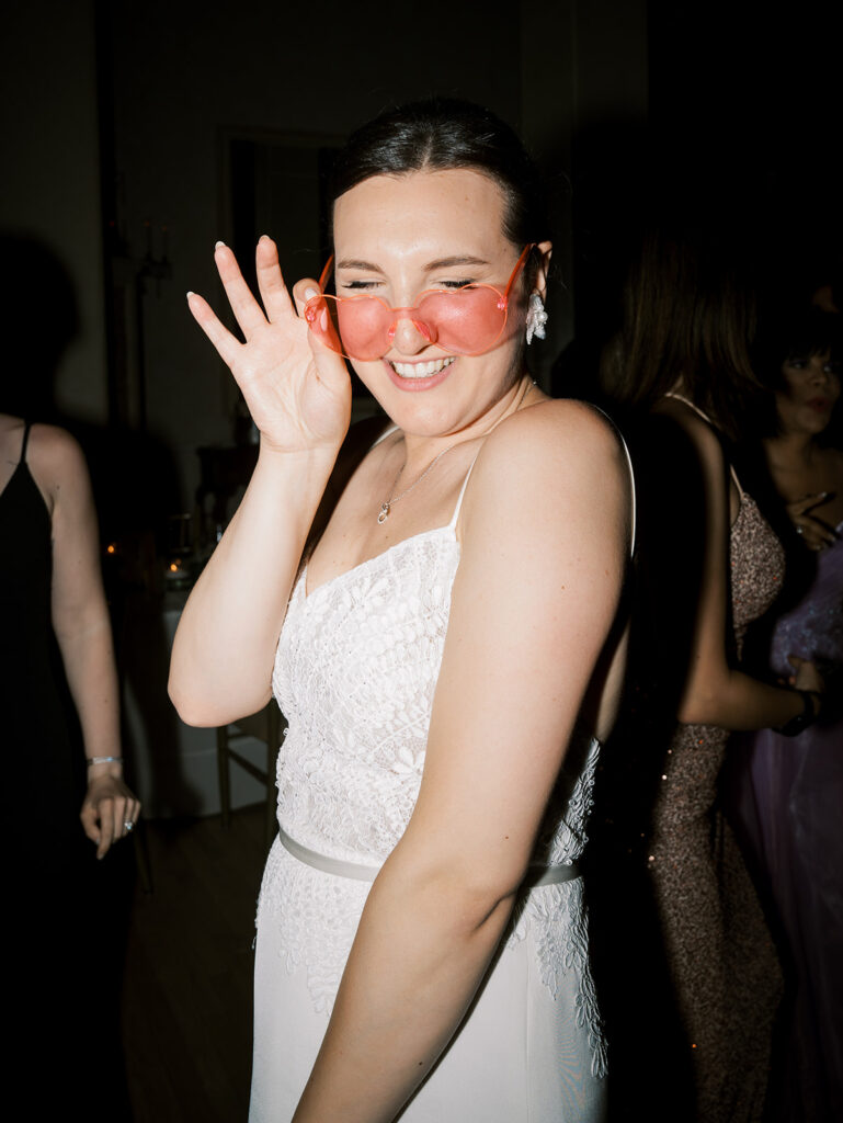 bride dancing at wedding reception at westchester country club wearing heart glasses