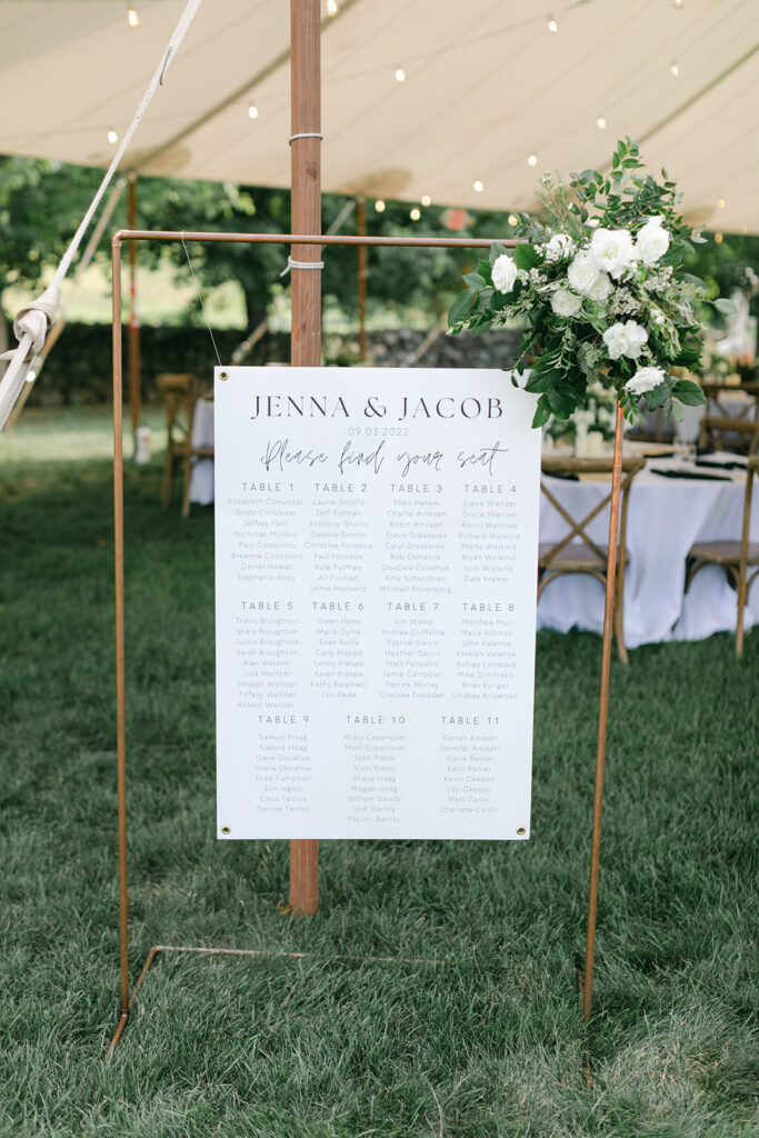 Large gold seating chart at outdoor wedding reception