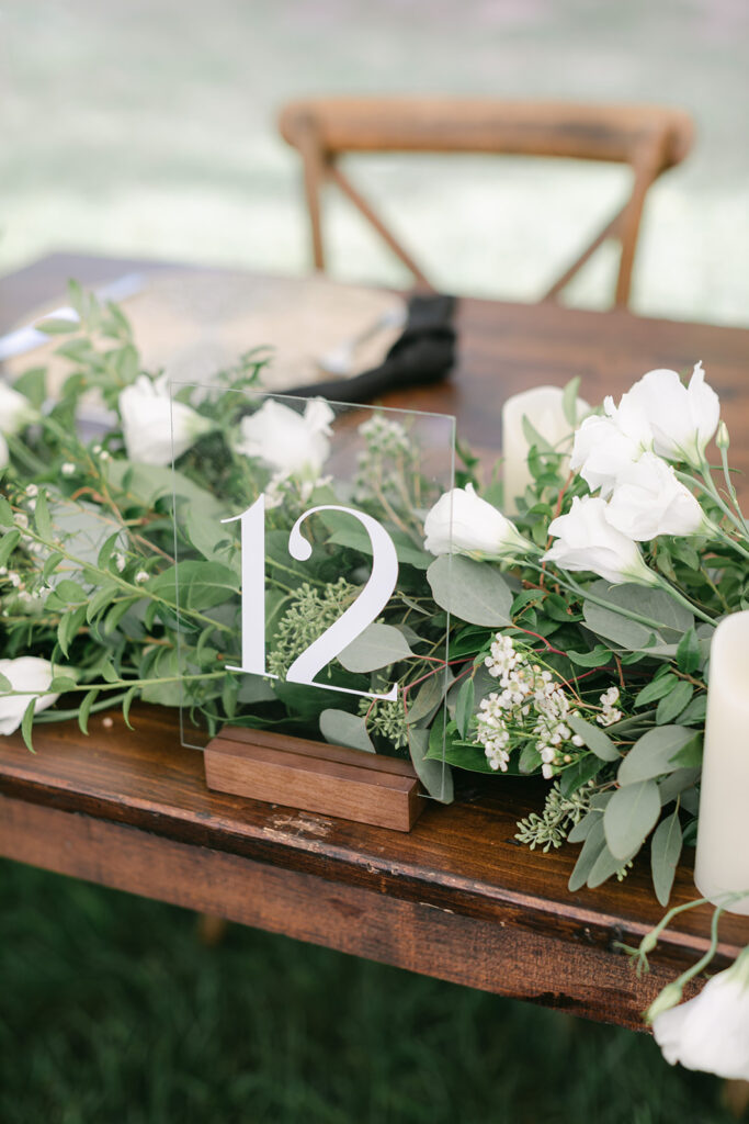 Acrylic table numbers on wooden table at wedding reception