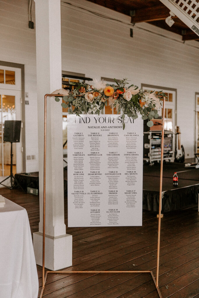 Floral and gold seating chart at wedding reception
