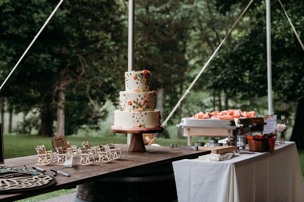 dessert table at wedding reception at candlelight farms in, cake with coral flowers on it